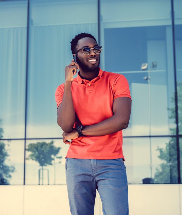 Smiling Black male dressed in a red polo shirt.