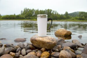 White travel mug mockup with big river stone